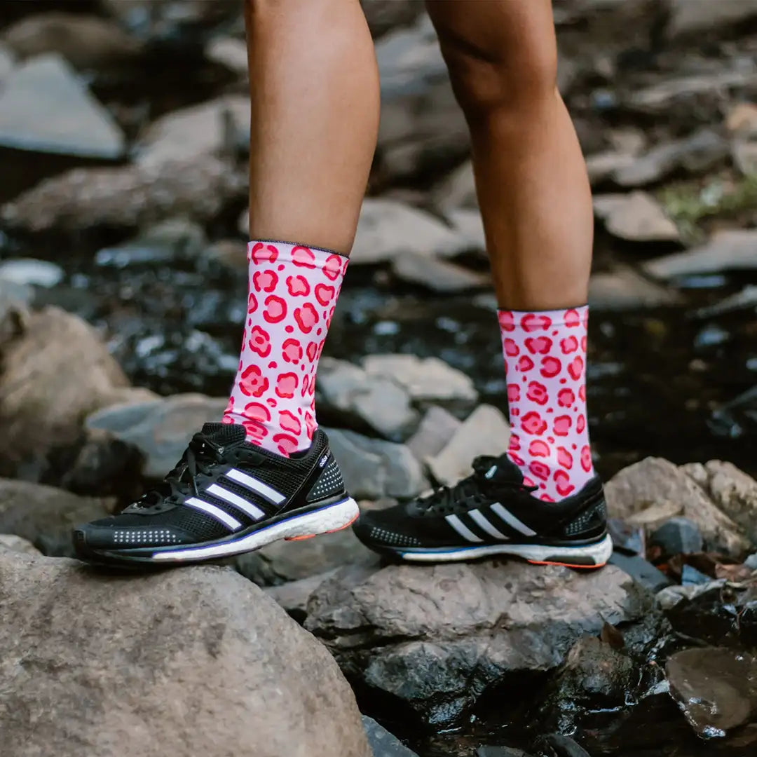 Calcetines con estampado rosa y rojos sobre fondo blanco de piel de leopardo