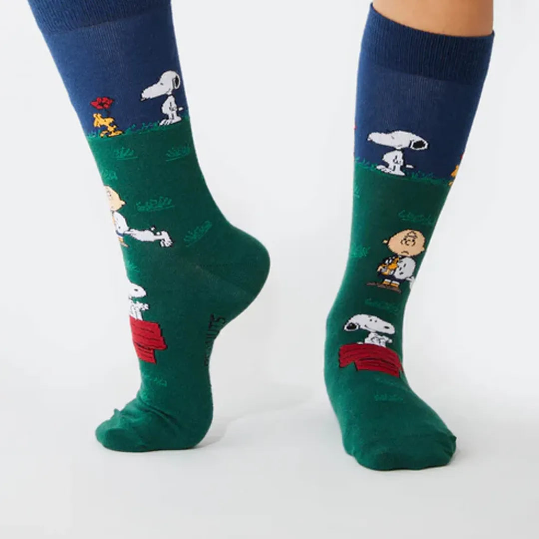 Fotografía de calcetines con motivo de snoopy sobre piernas reales